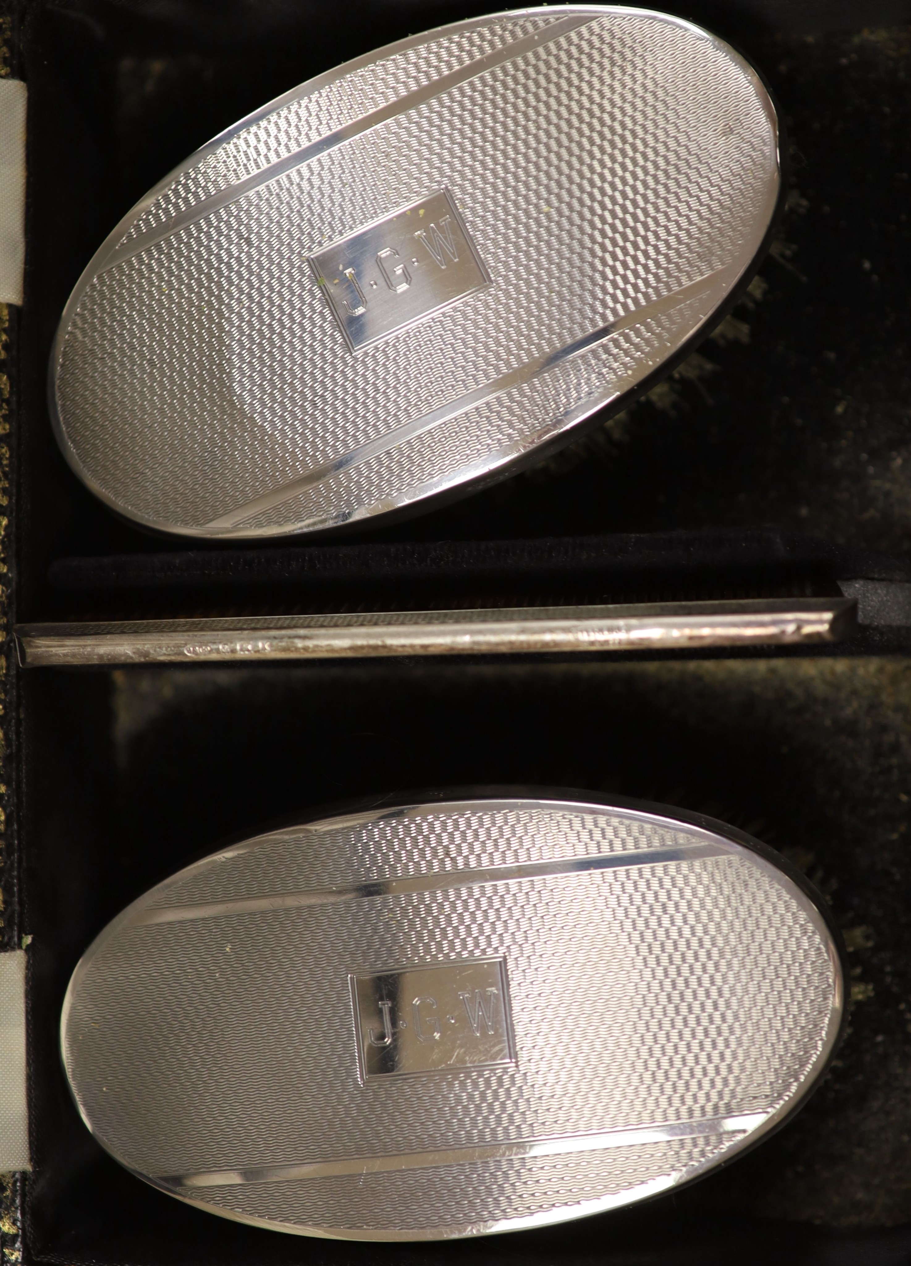 A cased pair of silver clothes brushes, silver quaich-type trophy and a George III silver dessert spoon.